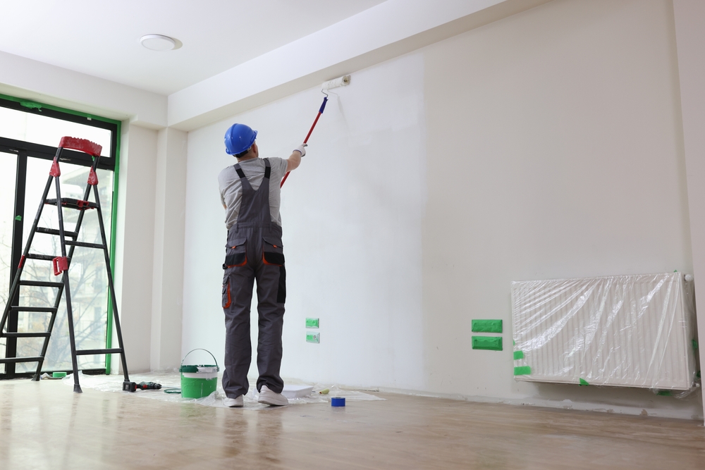 Een visuele weergave van het proces van zelf renovlies aanbrengen en schilderklaar maken. Een muur bedekt met hoogwaardig renovliesbehang, netjes aangebracht met behulp van een behangspatel. De afbeelding illustreert de nauwkeurigheid en zorg die nodig zijn voor een perfecte schilderklaar basis.